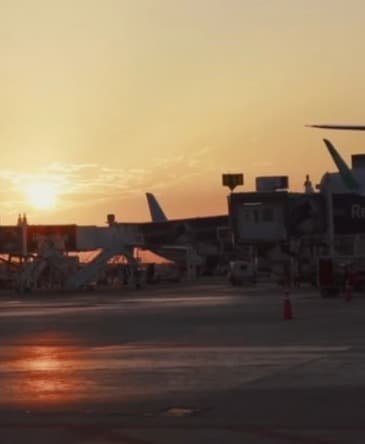 Atardecer sobre la pista de un aeropuerto con aviones